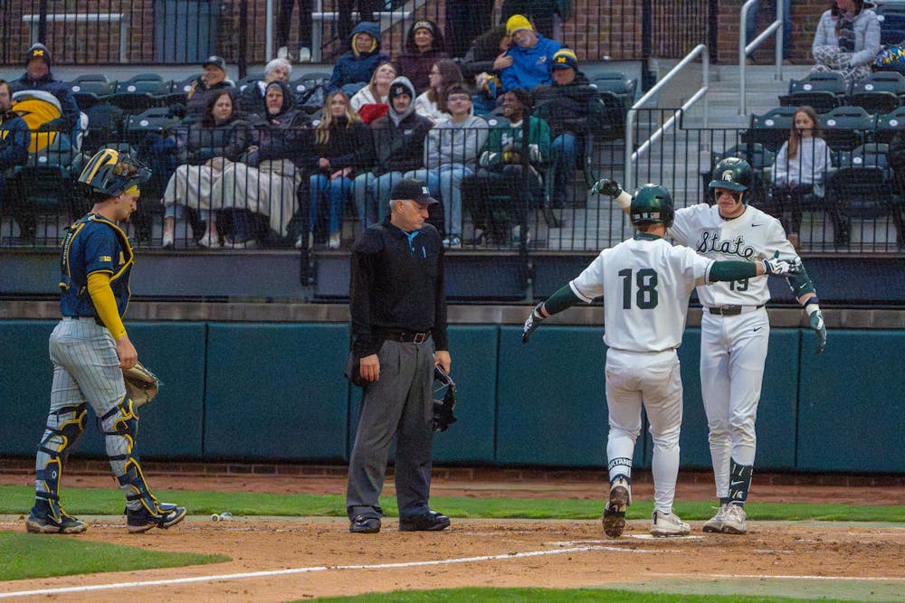 Michigan State designated hitter Noah Bright, 18, and catcher Adam Broski, 19, hug after Bright completes a run during Michigan State’s game against Michigan at Jeff Ishbia Field at McLane Stadium in East Lansing, Mich., on Friday, April 10, 2026.