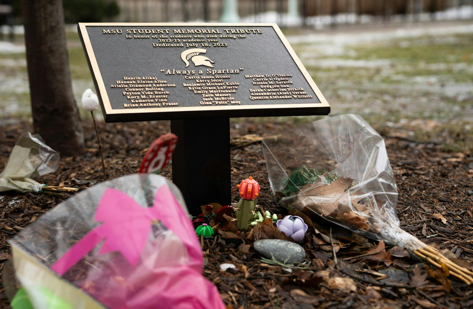 Flowers and other offerings rest at a student memorial including the names of the Feb. 13, 2023 campus shooting victims outside Berkey Hall on Feb. 3, 2025.