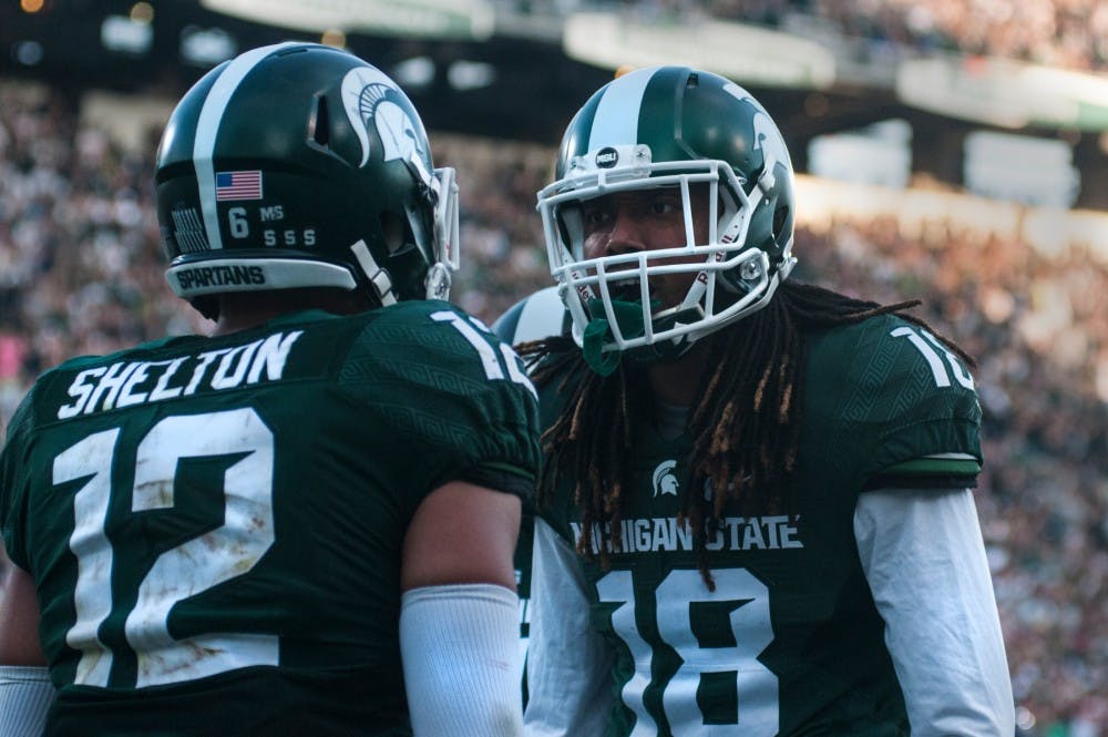 Senior wide receiver R.J Shelton (12), left, talks with sophomore wide receiver Felton Davis III (18) after scoring a touchdown in the third quarter during the game against Northwestern on Oct. 15, 2016 at Spartan Stadium. Shelton caught the 86 yard pass from senior quarter back Tyler O'Connor (7). 