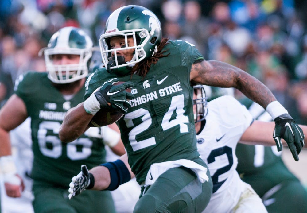 Sophomore running-back Gerald Holmes, 24, runs the ball in for a touchdown during the second quarter of the game against Penn State on Nov. 28, 2015 at Spartan Stadium. The Spartans defeated the Nittany Lions, 55-16.