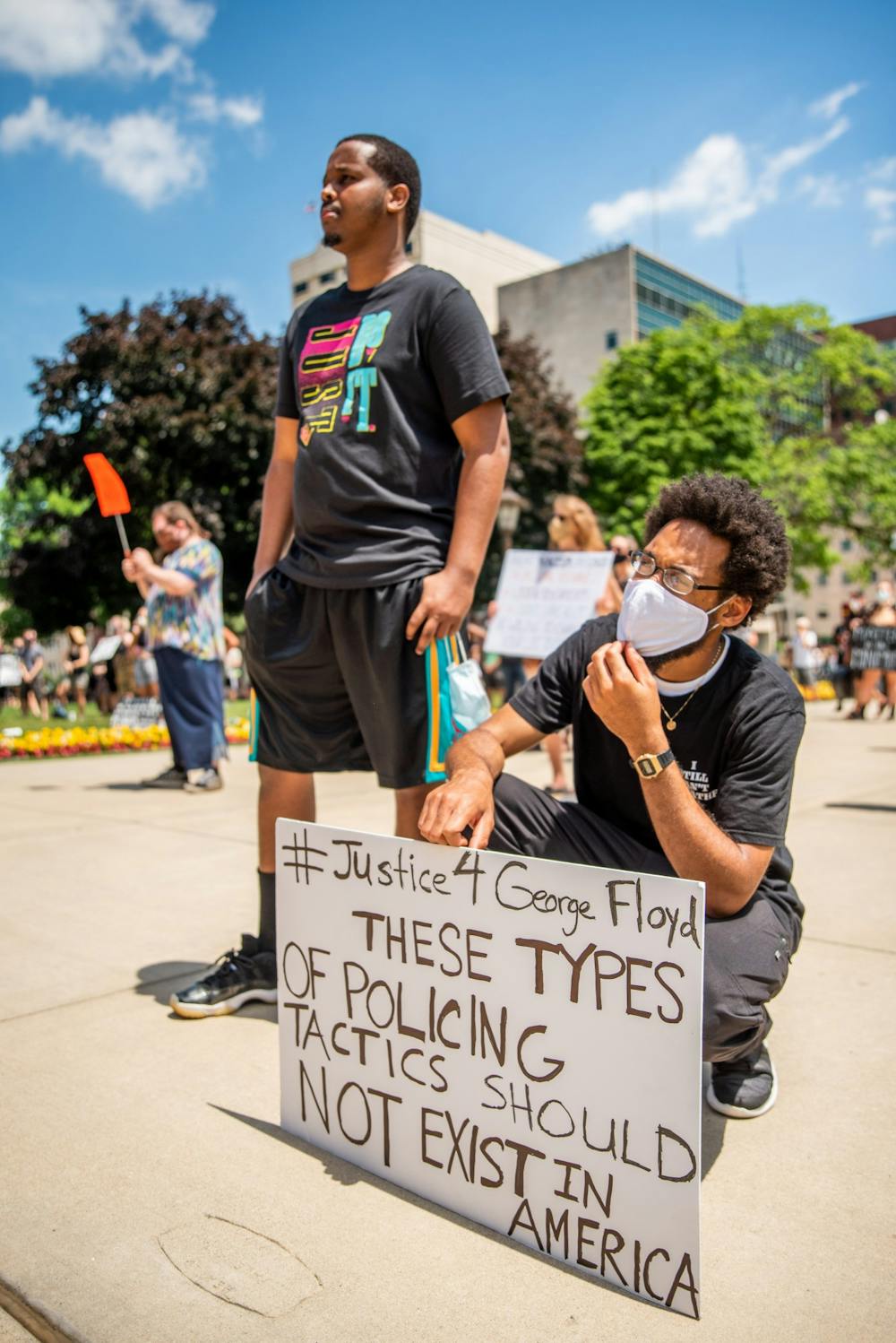 Farhan Sheikh-Omar (left) and Tory Conway (right) listen to speakers at the BLM rally at the Capitol June 29, 2020. Both Sheikh-Omar and Conway have been vocal advocates against police brutality in the Lansing community, speaking at city council meetings and other protests.