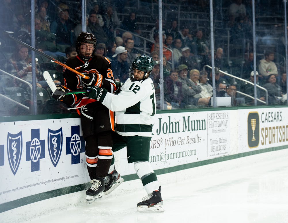 <p>Graduate forward Justin Jallen (12) fights against Bowling Green during a game against Bowling Green State University at Munn Ice Arena on Oct. 7, 2022. The Spartans lost against the Falcons with a score of 3-1. </p>