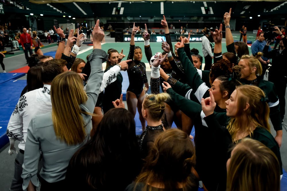 <p>The MSU Women’s Gymnastics team huddles together after finishing the uneven bars during a meet against Nebraska. The Spartans fell to the Cornhuskers, 196.550 - 197.100, at Jenison Fieldhouse on Jan. 26, 2020. </p>