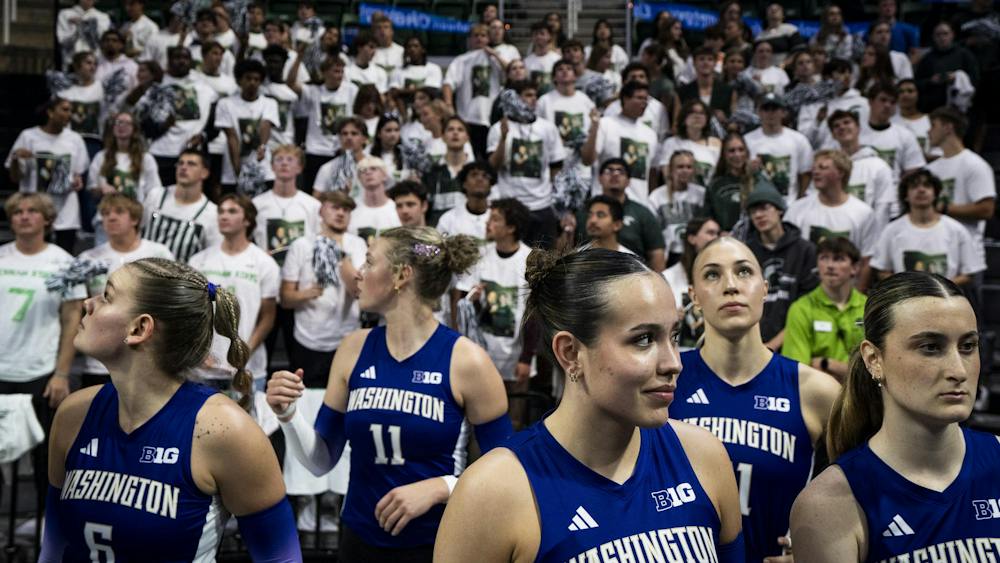 The University of Washington volleyball team looks around while Michigan State’s starting lineup is announced before a match at the Breslin Center in East Lansing, Mich., on Friday, Sept. 2026.