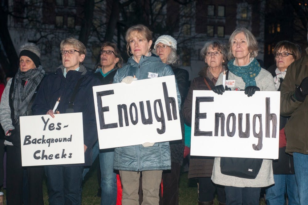 From left to right, Rochester Hills Mich., resident Jill McKinney, Milford Mich., resident Laura Trout and Milford Mich., resident Sherri Masson hold signs and listen to a speaker during a vigil held by the Michigan Coalition to Prevent Gun Violence on Dec. 9, 2015 at the Capitol Building. Representatives from faith groups throughout Lansing and victims of the effects of gun violence spoke to the crowd. Those in attendance were encouraged to sign post cards urging their state representatives to veto Bill 442, which would allow certain individuals with concealed weapon permits to have guns in no-carry zones, like schools, hospitals and public libraries. 