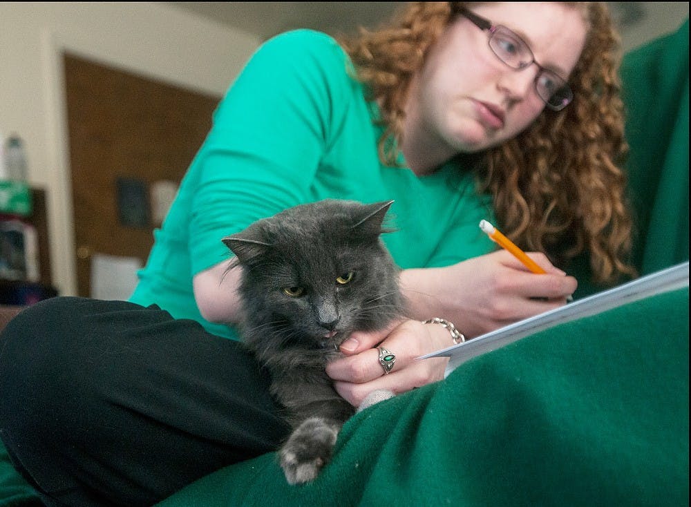 	<p>Graduate student Kate Londy studies with her therapy cat Jasmine on Jan. 27, 2014, at her apartment in East Lansing. Londy said since getting Jasmine, her blood pressure has gone down from 130/85 to 110/75 for the first time in six years. Erin Hampton/The State News</p>