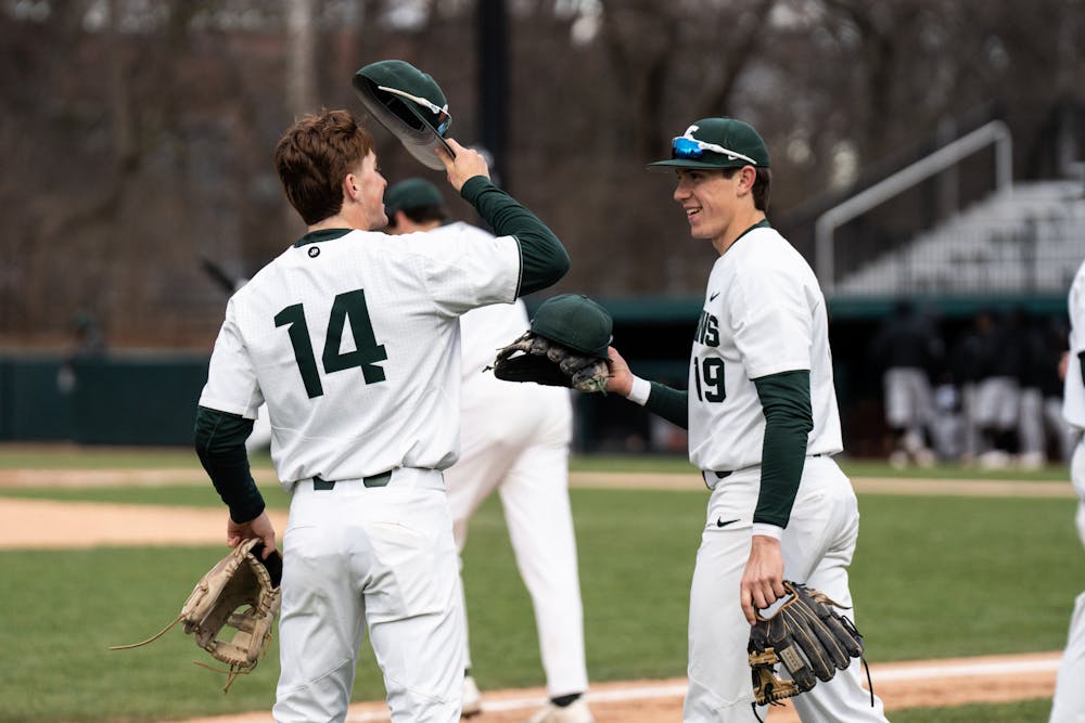 <p>MSU redshirt freshman Bryan Broecker hands supplies off to fellow teammate Mitch Jebb during the Oakland matchup on April 19th, 2022. </p>