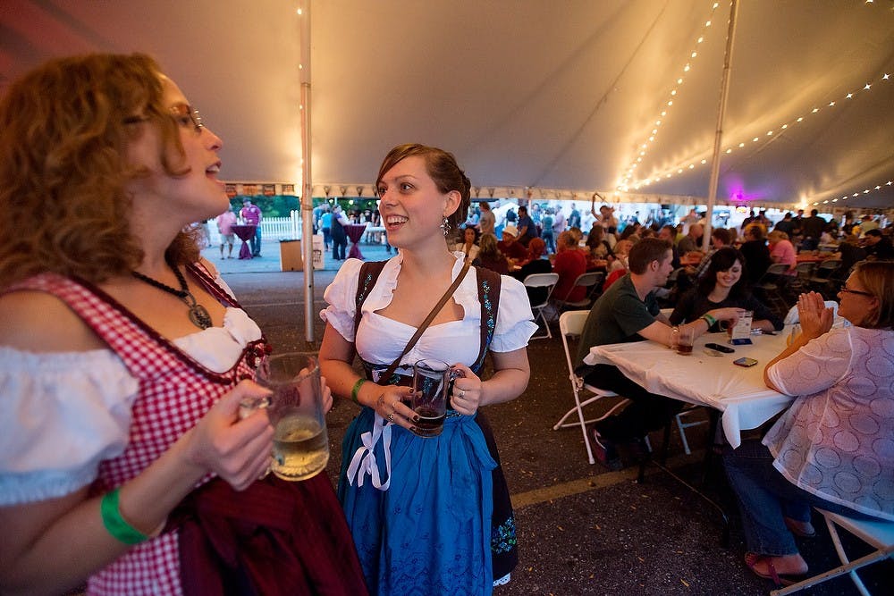 	<p>Lansing residents Emily St. Clair, right, and Sarah Coston chat Oct. 4, 2013, during Old Town Lansing Oktoberfest. Coston said she dresses up each year for Oktoberfest. Julia Nagy/The State News</p>