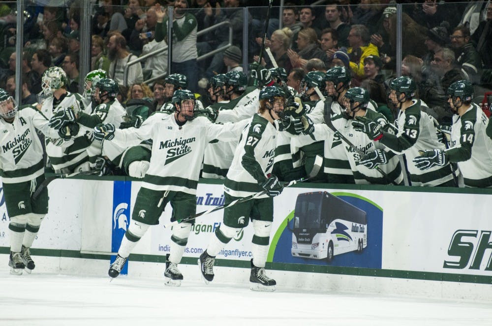 The Spartans high five after scoring a goal during the second period of the men's hockey game against Wisconsin on Feb. 4, 2017 at Munn Ice Arena. The Spartans were defeated by the Badgers, 3-4.