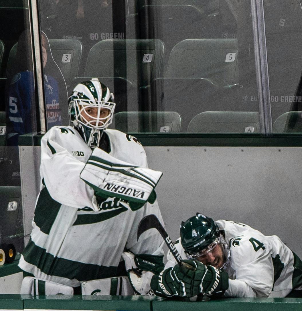 <p>DeRidder points at freshman defender Nash Nienhuis (4), who seconds before had slammed his head into the wall and skated off in pain. The Badgers shut out the Spartans 4-0 at Munn Ice Arena on March 5, 2021. </p>