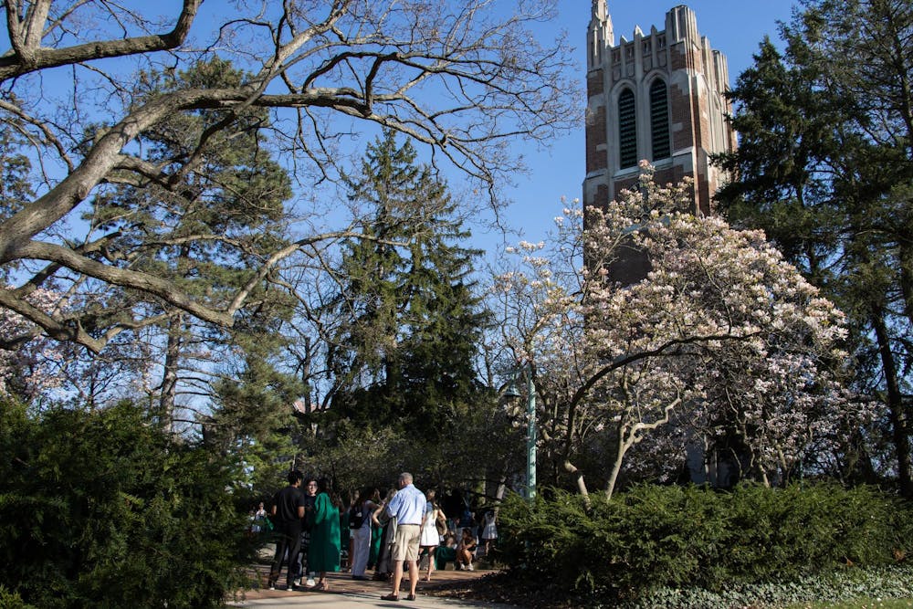 Michigan State University graduates and others wait in line to take photos in front of Beaumont Tower on campus in East Lansing, Mich., Tuesday, April 22, 2026.