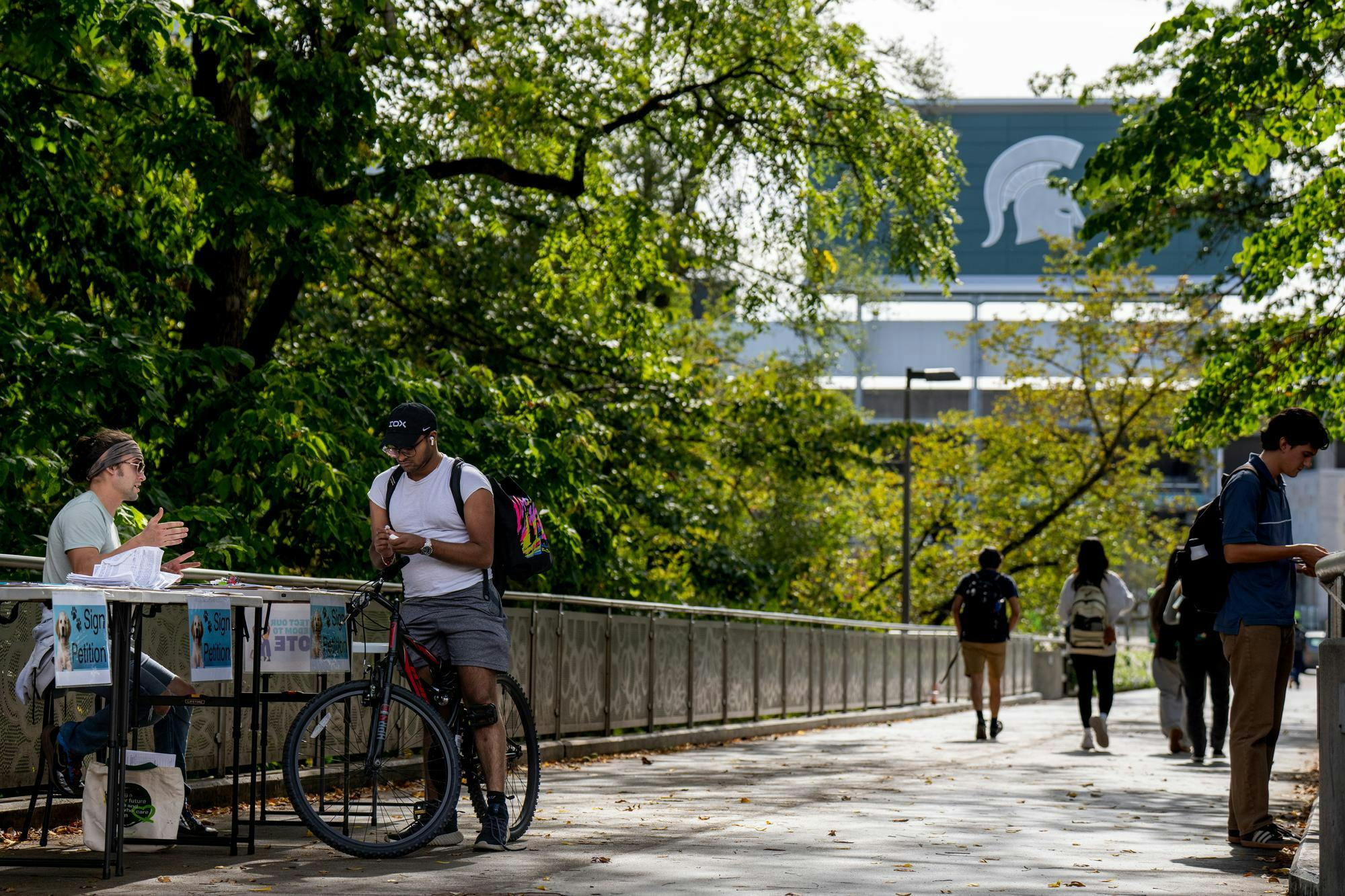 <p>Petitioners gather at MSU's Library Bridge in East Lansing, Michigan on Thursday, Oct. 2, 2025.</p>