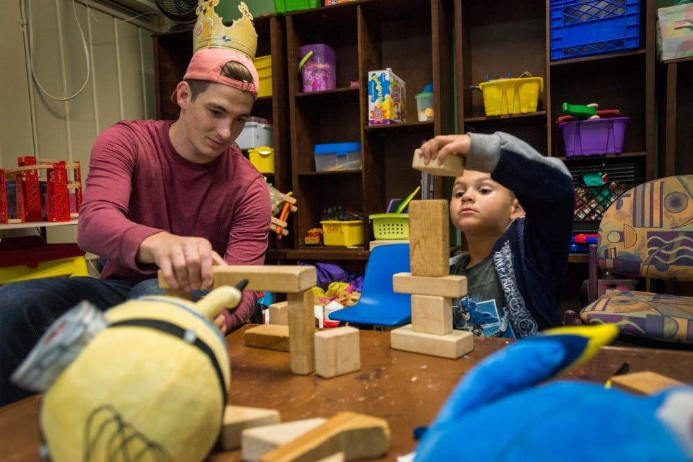 Mechanical engineering junior Josh Wojtowiczon and East Lansing resident Leon Strong, 5, play with blocks on Sept. 30, 2016 at Haven House at 121 Whitehills Drive in East Lansing. Haven House provides temporary housing for families until they are able to find permanent housing elsewhere.