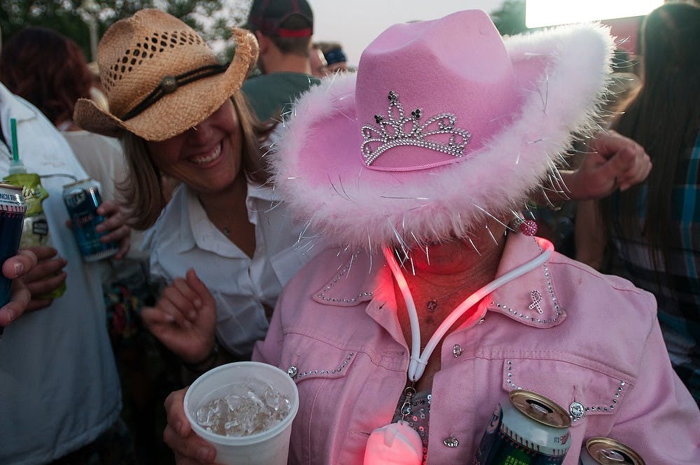 	<p>Lansing resident Stephanie Nye, left, dances with her mother, Muskegon, Mich., resident Ginny Nye, at Common Ground Music Festival on July 11, 2013, at Adado Riverfront Park in Lansing. Ginny donned all pink for Common Ground&#8217;s night of country music. Julia Nagy/The State News </p>