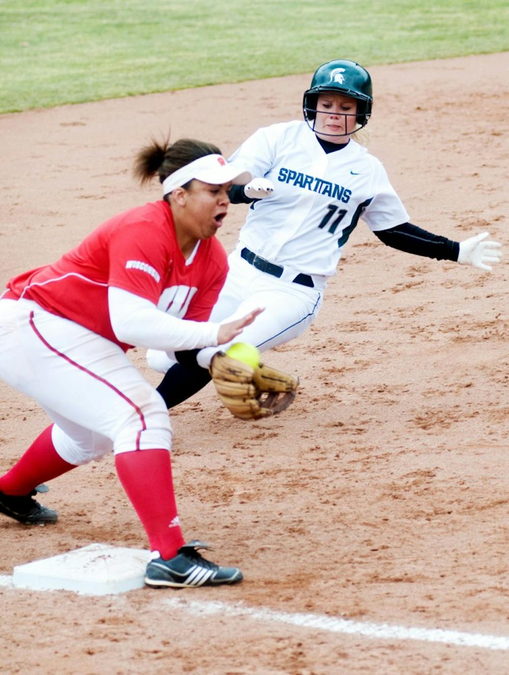 Senior first baseman Heidi Purtzer runs into third base as Wisconsin third baseman Shannel Blackshear catches the ball during Saturday's home game at Secchia Stadium. Lauren Wood/The State News