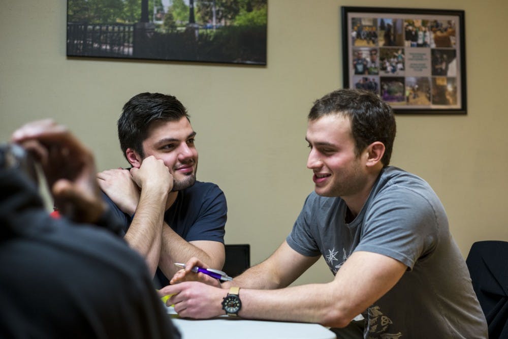 From left to right, Ben, who declined to give his last name, looks at Lenny, who also declined to give his last name, as Lenny talks about his week during the MSU Traveler's Club meeting on March 31, 2017 at Olin Health Center. The MSU Traveler's Club is a club that provides a social space and support for people who are in recovery from addiction. 