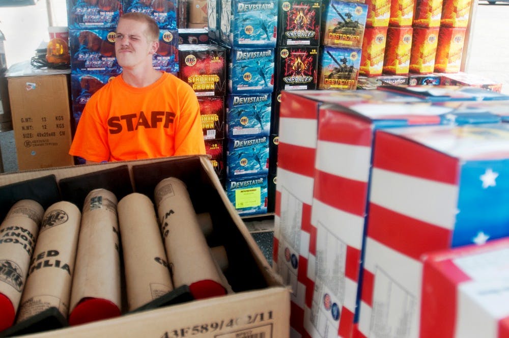 Lansing resident Devyn Ordiway waits for customers at an American Eagle Big Fireworks tent on the corner of W. Grand River and N. Homer Street on July 2, 2012. The Michigan Fireworks Safety Act, which became effective Jan. 1, 2012, legalizes all fireworks, except those used in professional displays.
