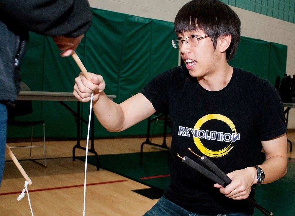 	<p>Computer science junior Mark Wu of the University of Michigan helps teach someone how to use a Chinese yo-yo at World Friendship Day on Saturday, March 16, 2013, at Spartan Village Community Center, 1460 Middleville Road. </p>