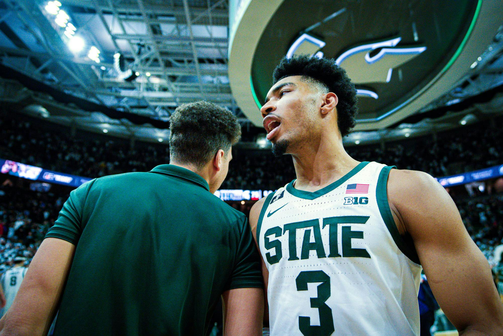 MSU senior guard Jaden Akins (3) celebrates with a coach following a win against Purdue at the Breslin Center on Feb. 18, 2025.