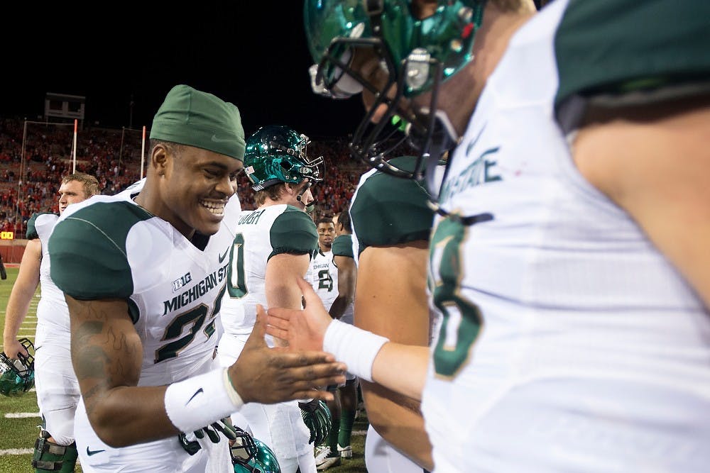 	<p>Sophomore quarterback Connor Cook and freshman running back Delton Williams high five on Nov. 16, 2013, at Memorial Stadium in Lincoln, Neb. after the game against Nebraska. The Spartans defeated the Cornhuskers, 41-28. Julia Nagy/The State News </p>