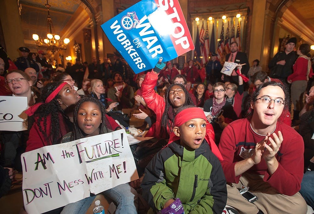 	<p>Protesters sit on the floor, Tuesday, Dec. 11, 2012, at the Capitol in Lansing to protest the passage of the right-to-work laws. Thousands participated in the rally to protest the right-to-work laws. Justin Wan/The State News</p>