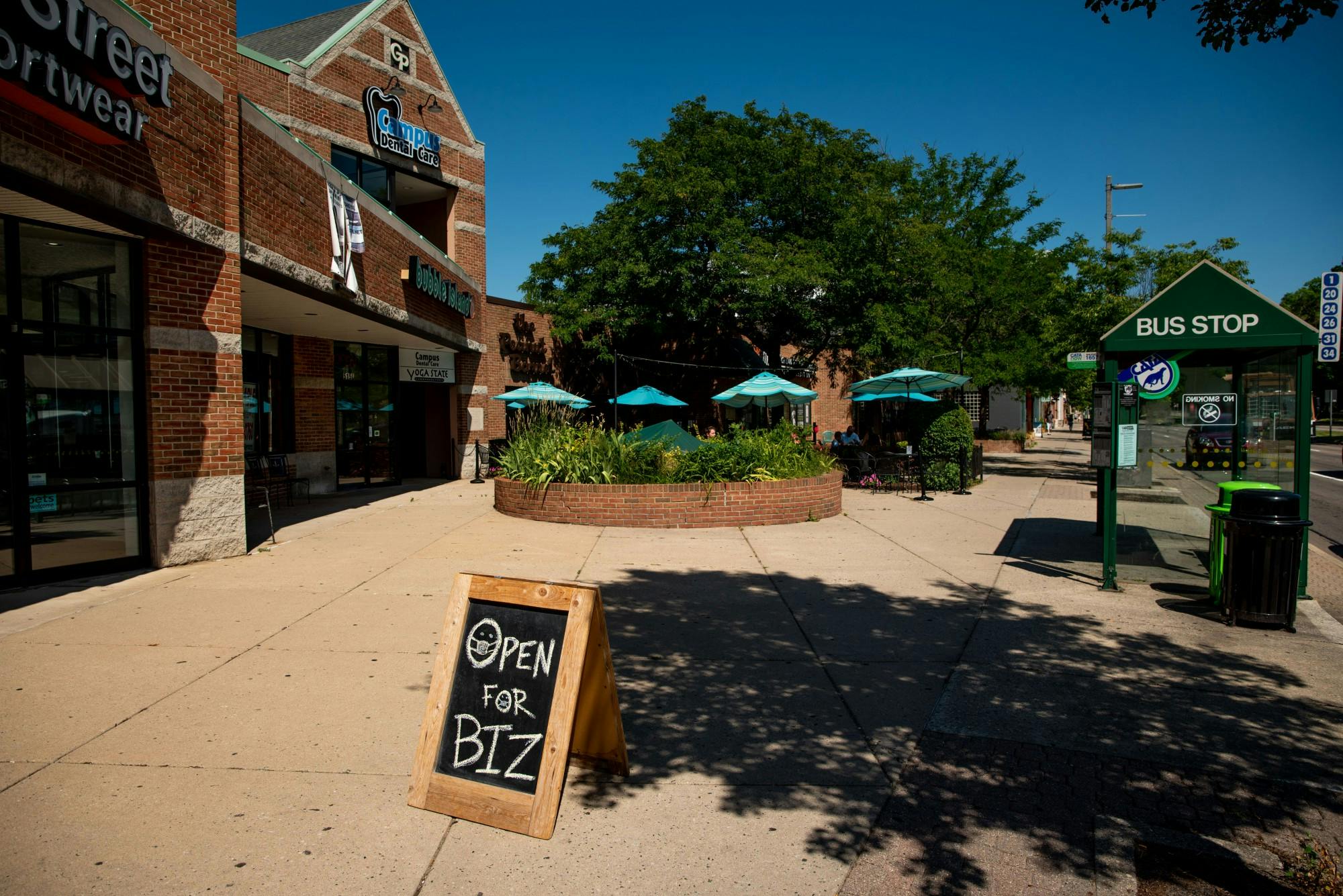 <p>A sign showing that businesses are open despite recent COVID-19 outbreaks in downtown East Lansing is pictured Jun. 30, 2020.</p>