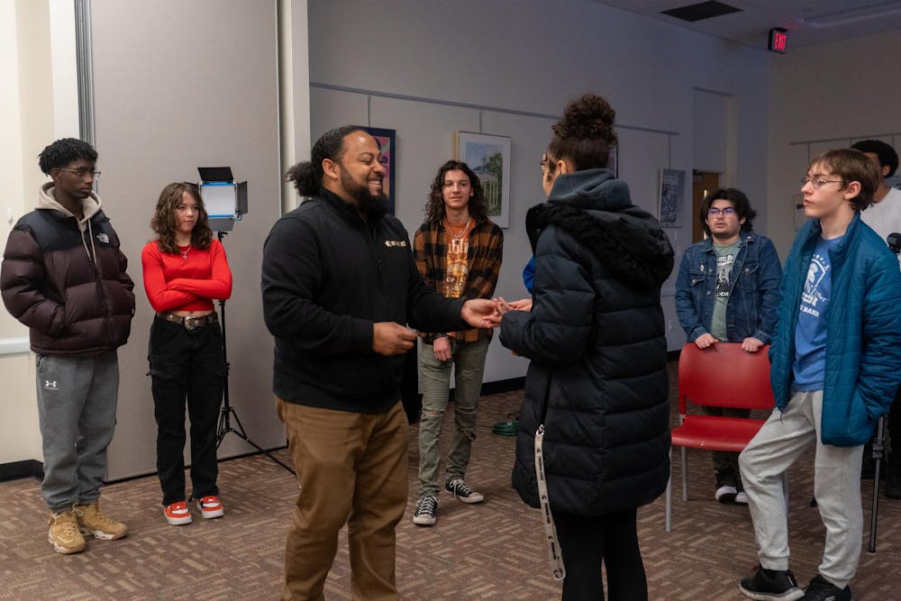 Pop Up Docs founder and MSU artist-in-residence, Jarrad Henderson, laughs with a student while teaching audio on Jan. 20, 2024.  The Intro to Documentary Filmmaking Workshop took place at the East Lansing Public Library on Jan. 19, 20, 26, and 27, 2024.