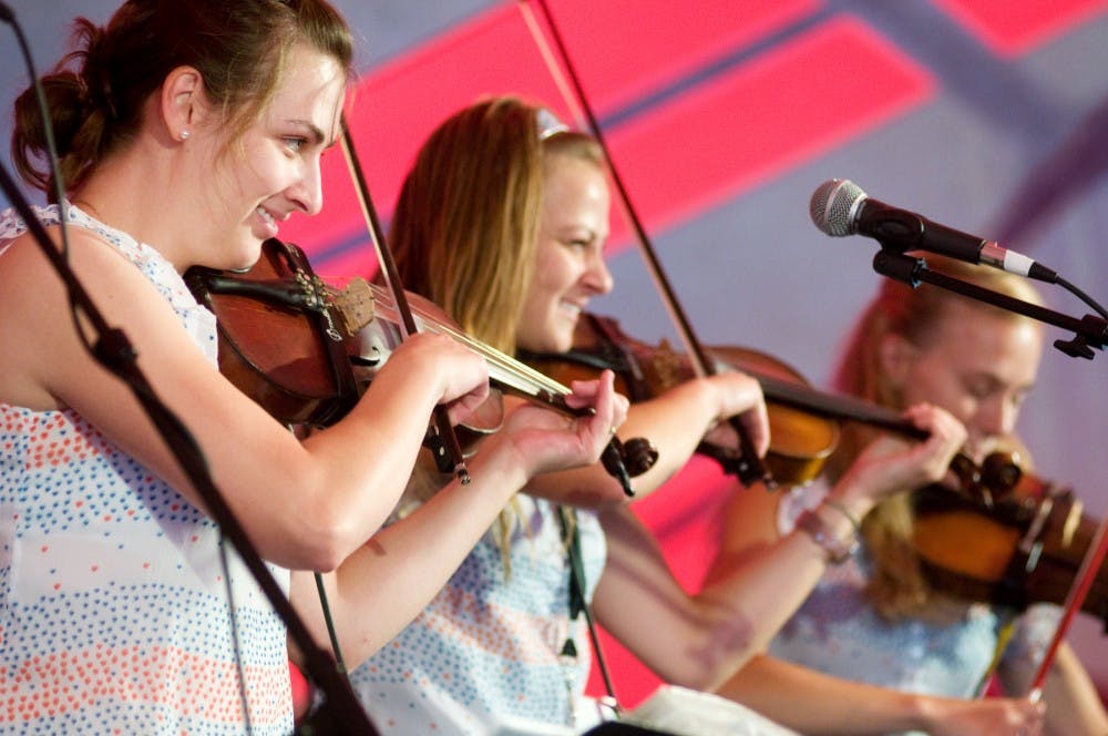 <p>From left, sisters Kristine Babiarz, Erika Piotrowski and Andrea Piotrowski, all Muskegon, Mich., residents, perform with their family band, Pan Franek and Zosia’s Polka Towners, on Sunday at the Great Lakes Folk Festival in East Lansing. </p>