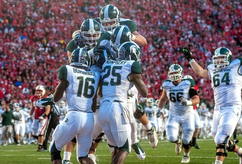 Spartan football players celebrate in the endzone after junior wide receiver Bennie Fowler catches the winning touchdown Saturday, Oct. 27, 2012, at Camp Randall Stadium in Madison, WI. The Spartans defeated the Wisconsin Badgers 16-13 with an overtime touchdown for the win. Adam Toolin/The State News