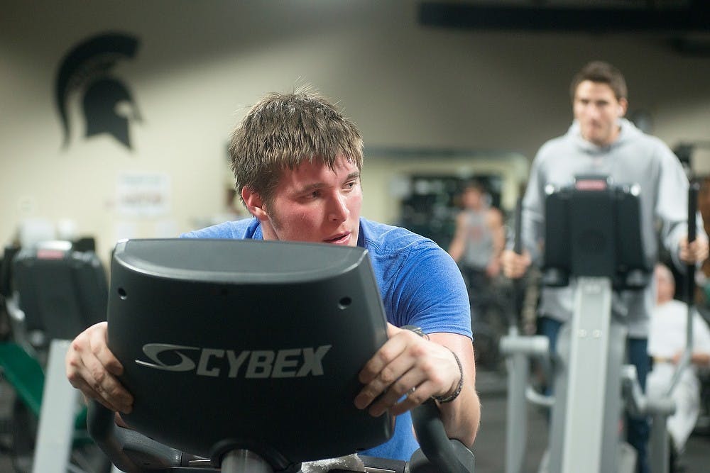 	<p>Human biology junior Nico Harrington bikes Feb. 18, 2014, at Powerhouse Gym, 4790 S Hagadorn Rd. Harrington is training for a charity event with his members of his fraternity, Pi Kappi Phi, this summer to bike 800 miles across Florida and stop at needy homes with disabled family members to give them money. Julia Nagy/The State News</p>