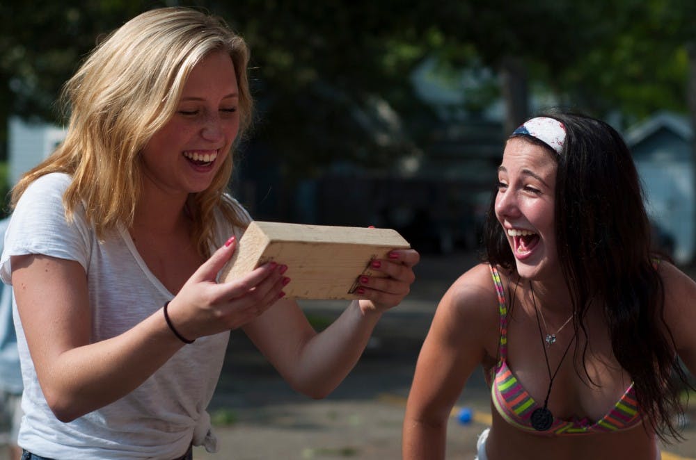 <p>Hospitality business sophomore Megan Burnie, left, and hospitality business sophomore Madison Cummings playing giant Jenga on Sept. 7, 2015, at Pi Kappa Phi, 520 Linden, in East Lansing. "I am enjoying [Labor Day], it's been a great weekend," Burnie said. Treasure Roberts/The State News</p>