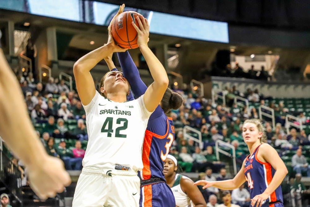 Freshman forward Kayla Belles (42) takes an elbow to the head while going up for a layup during the game against Virginia on Nov. 28, 2018 at Breslin Center. The Spartans lead the Cavaliers 46-26 at halftime.