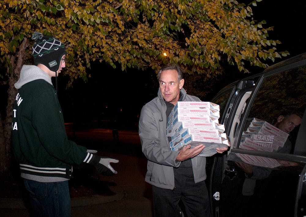 	<p><span class="caps">MSU</span> football head coach Mark Dantonio hands pizza boxes to journalism sophomore Nathan Kujacznski on Oct. 29, 2013, at the Sparty statue. The marching band guards the statue every year for the week leading up to the Michigan game. Georgina De Moya/The State News</p>