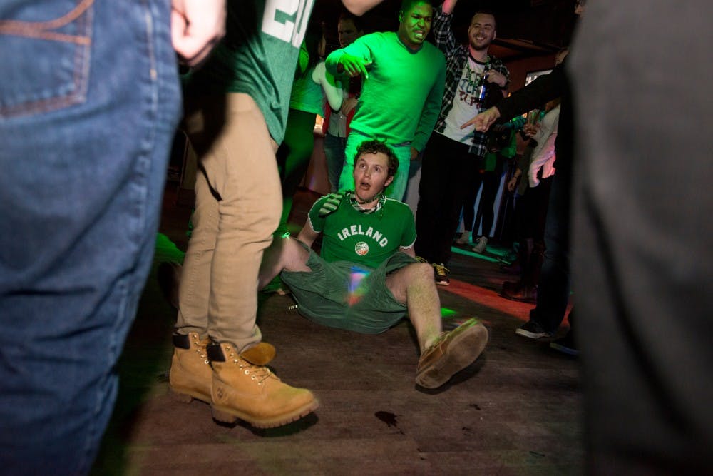 Advertising and communication senior Alex Byers sits on the dance floor on March 17, 2016 inside of Harper's Restaurant & Brew Pub at 131 Albert Ave. Harper's opened its doors at 7:00am to celebrate St. Patrick's Day.
