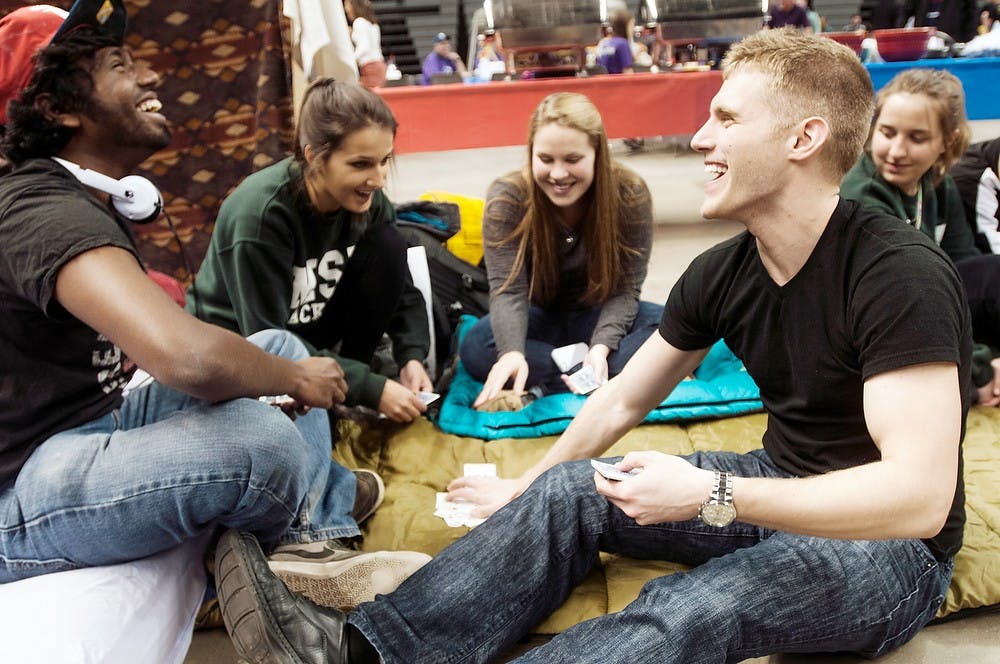 <p>Packaging junior Matt Somaiah, left, and packaging senior Nick Salic play cards during Relay for Life on March 28, 2014, at Breslin Center. The group entertains themselves during the 12-hour fundraiser by playing cards. Allison Brooks/The State News</p>