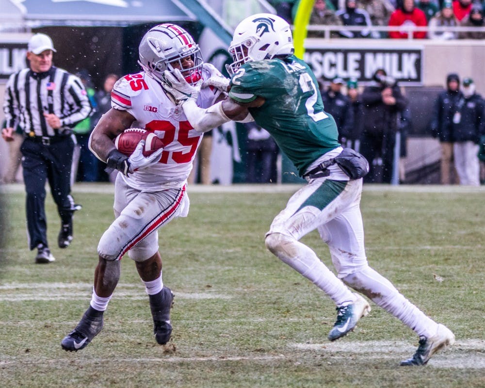 Junior cornerback Justin Layne (2) attempts to tackle Ohio State running back Mike Weber Jr. (25) during the game against Ohio State Nov. 10, 2018. The Spartans fell to the Buckeyes, 26-6.