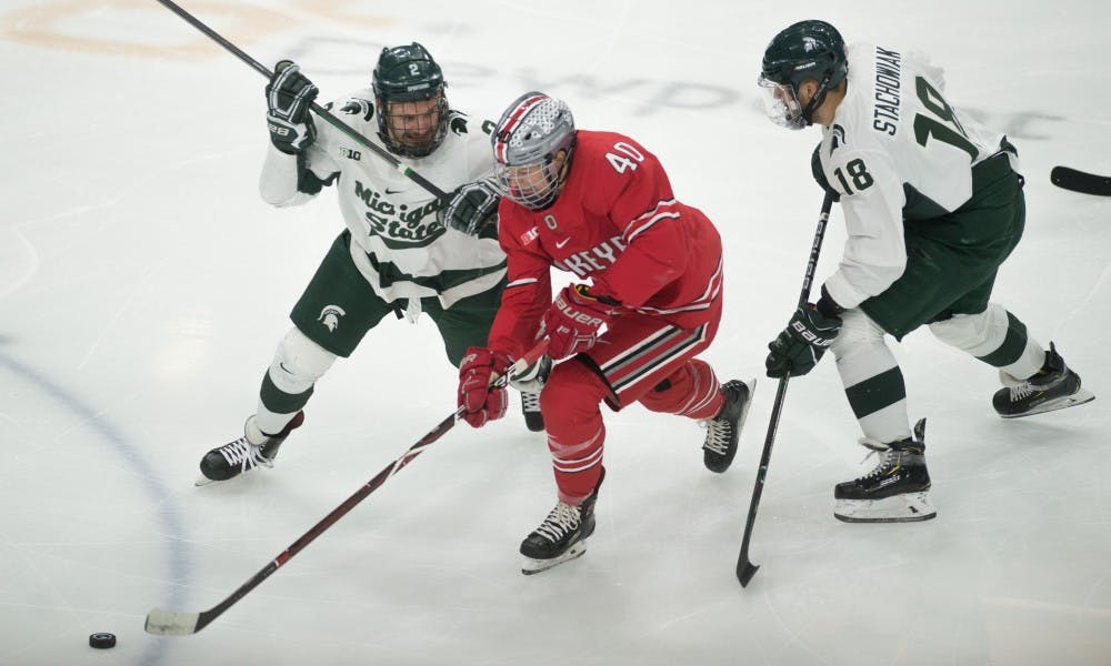 Senior defenseman Zach Osburn (2) and freshman left wing Wojciech Stachowiak (18) block Ohio State center Ronnie Hein (40) during the game against Ohio State University at Munn Ice Arena on Jan. 5, 2019. The Spartans fell to the Buckeyes, 6-0.