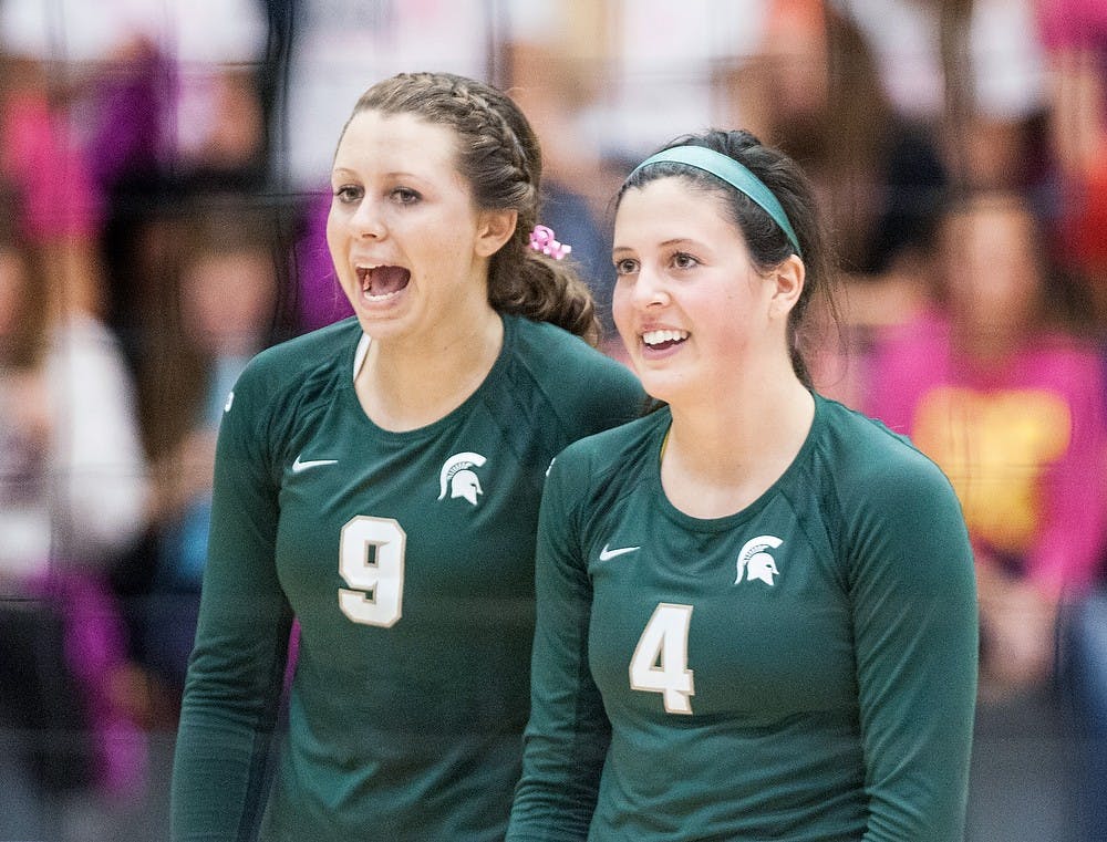 	<p>From left, sophomore outside hitter Taylor Galloway and freshman setter Halle Peterson talk after a volley Wednesday night, Oct. 17, 2012, at Cliff Keen Arena in Ann Arbor, Mich. The Spartans defeated the Michigan Wolverines in three straight sets (25-20, 25-17, 25-20). Adam Toolin/The State News</p>