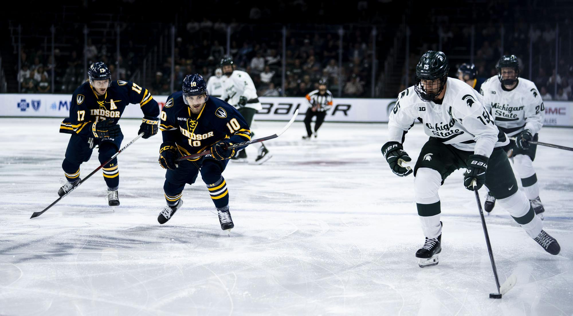 MSU senior forward Charlie Stramel (15) takes the puck in the Munn Ice Arena on Oct. 3, 2025. MSU defeated Windsor 4-0. 