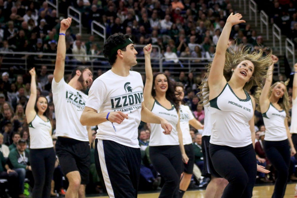 Members of the Izzone perform with the MSU Dance Team during halftime of the game against Indiana on Feb. 14, 2016 at Breslin Center. 