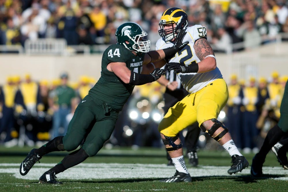 <p>Senior defensive end Marcus Rush tries to push past Michigan offensive lineman Mason Cole on Oct. 25, 2014, at Spartan Stadium. The Spartans defeated the Wolverines, 35-11. Julia Nagy/The State News</p>