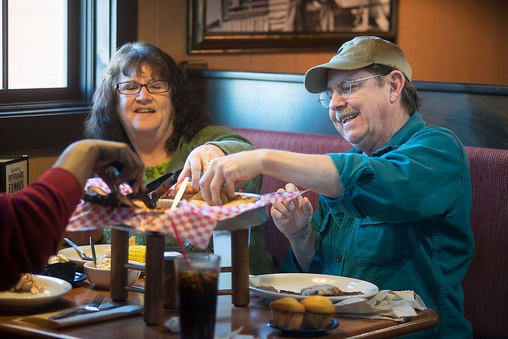 <p>Grayling residents Darlina Welt, left, and John Welt enjoy their meal with Lansing resident Joyce Lightfoot on Mar. 17, 2015, after ordering the Feast for Two at Famous Dave's, 2457 Cedar St. in Holt. Emily Nagle/The State News</p>