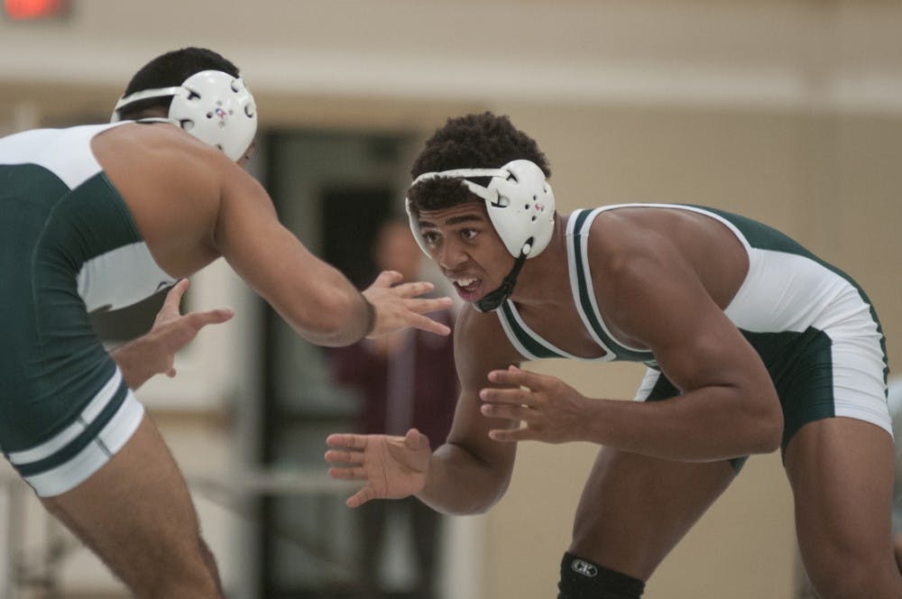 Redshirt-junior Javier Gasca (white) prepares to grapple with freshman Jwan Britton (green) during the wrestling team's green and white day on Oct. 27, 2016 in IM-Sports West.