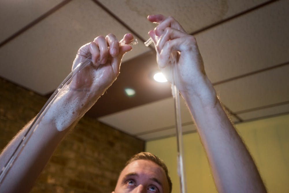 Holt, Mich. resident Jacob Schopp attaches two tubes for the siphon process to begin on June 6, 2016 at Capital City Homebrew Supply at 623 E. Michigan Ave. in Lansing, Mich. The auto siphon is used to transfer beer from one source to another.