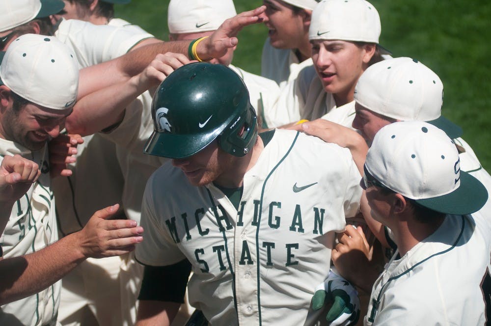 	<p>Spartans celebrate a home run hit by junior catcher Joel Fisher in the eighth inning after the hit drove in three runs in the third game of the series against the University of Illinois on May 5, 2013, at McLane Baseball Stadium at Old College Field. The Spartans won 4-3 after trailing 3-1 for a majority of the game. Danyelle Morrow/The State News</p>