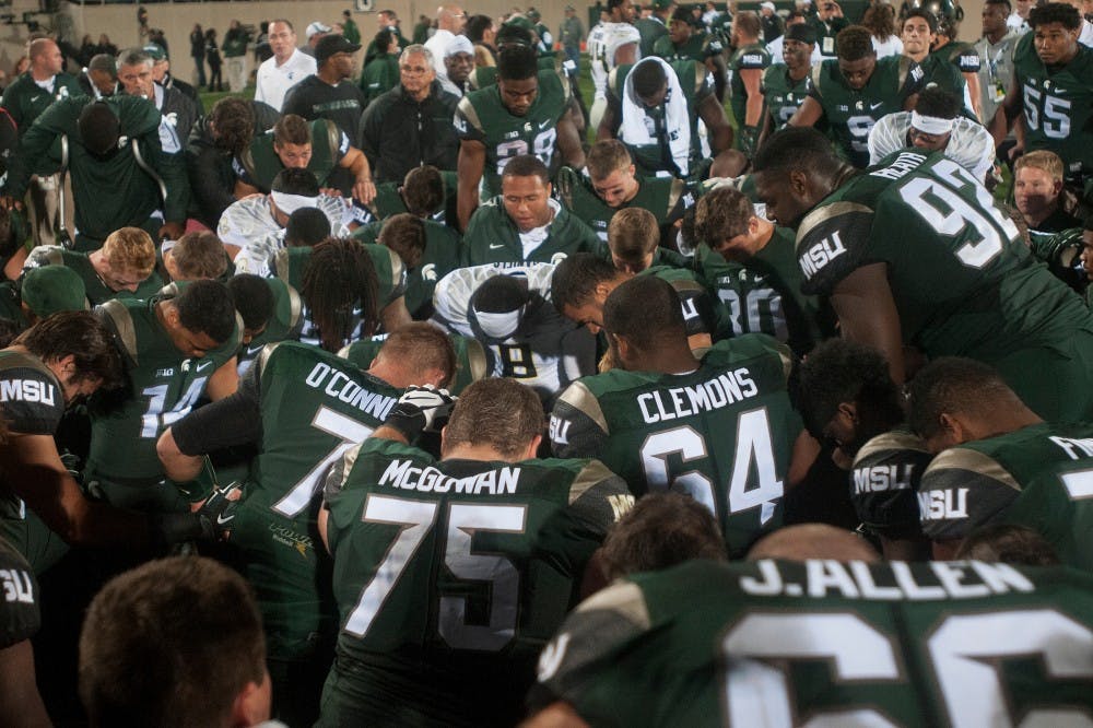 <p>The Michigan State football team says a prayer after the game against Oregon on Sept. 12, 2015 at Spartan Stadium. The Spartans defeated the Ducks 31-28. Alice Kole/The State News</p>