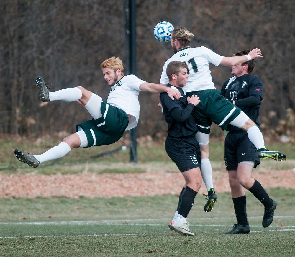 <p>Senior defender Ryan Keener and junior defender Zach Carroll fight to gain possession of the ball with a header against Providence College defender Brandon Adler and forward Mac Steeves on Dec. 6, 2014, at DeMartin Stadium at Old College Field. The Spartans were defeated by the Friars, 2-3. Raymond Williams/The State News</p>
