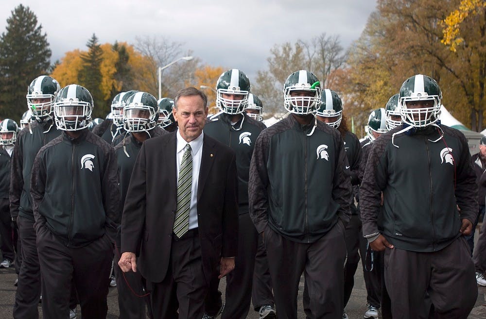 	<p><span class="caps">MSU</span> football head coach Mark Dantonio walks with the team towards the Spartan Stadium before the game against Michigan on Nov. 2, 2013 on Red Cedar Road. The Spartans defeated the Wolverines, 29-6. Georgina De Moya/The state News</p>