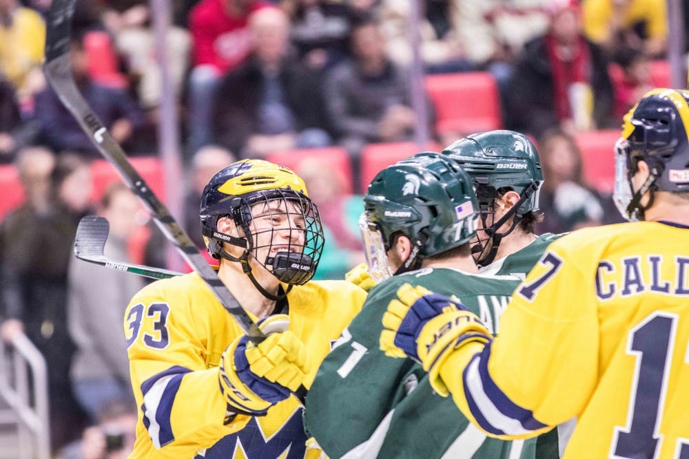 Sophomore forward Logan Lambdin (71) gets into a shoving match with a Michigan player on Feb. 10, 2018, at Little Caesars Arena. The Spartans fell to the Wolverines, 3-2.