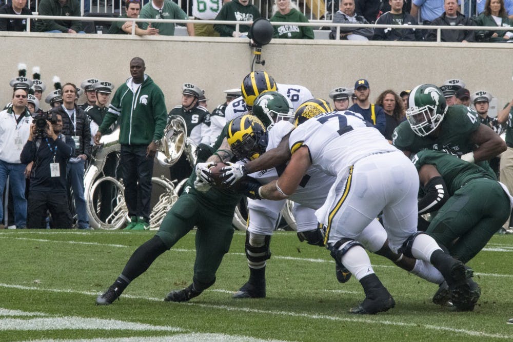Senior running back De'Veon Smith (4) reaches for the goal line during the game against Michigan on Oct. 29, 2016 at Spartan Stadium. The Spartans were defeated by the Wolverines, 32-23.  